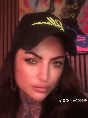 Een klant draagt de zwarte Chico Basic Curved Brim Cap met een neongroen logo.