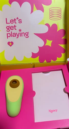 Customer's avocado-shaped Avo Clitoral Massager displayed in its open pink box.