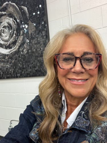 Reviewer smiling while wearing Woo Gossamer® Lashes with her stylish glasses.