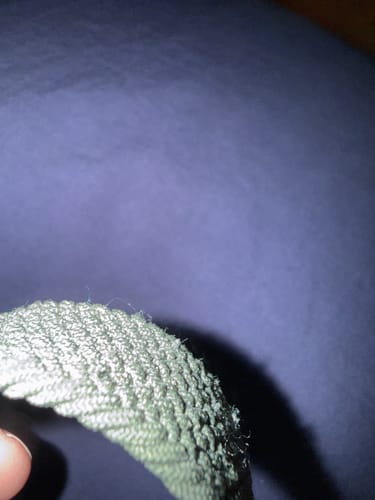 Close-up: Reviewer's Nylon Braided Solo Loop Band showing frayed and peeling fibers along the edge.
