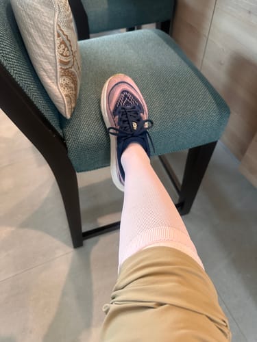 Customer wearing light-colored Performance Eucalyptus Compression Socks on one leg with a sneaker.