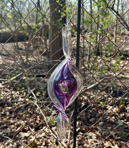 Customer's beautiful purple Dichroic Spinner Suncatcher hanging in a garden.