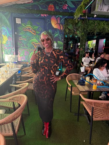 Reviewer at a restaurant wearing the Bare Body Tortoise Cardigan Top with the matching maxi skirt.