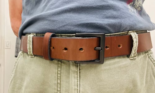 Reviewer wearing the thick brown leather Everyday belt with its matte black buckle.