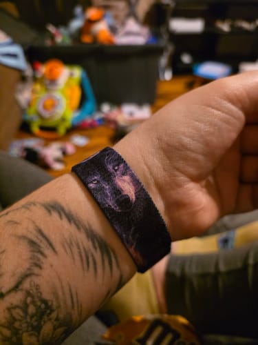 Customer wearing the Stand Your Ground Watchband on their tattooed wrist, showing the detailed wolf face design.