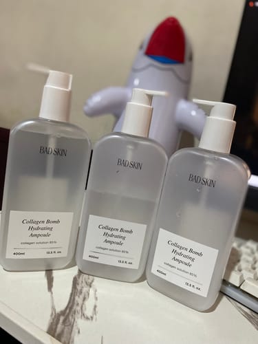 Reviewer's three bottles of Bad Skin Collagen Bomb Hydrating Ampoule on a desk, showing their repeat purchase.