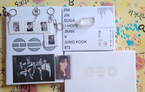Customer displays their BTS ARIRANG 5TH ALBUM SET, including two white album boxes, various photocards, and selfie keyrings.