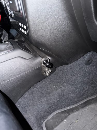 Customer's universal accessory mount installed on the passenger side of their Jeep's dark center console.