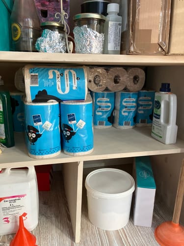 Photo d'un client montrant plusieurs paquets de PAPIER TOILETTE CONFORT rangés sur une étagère.