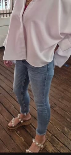 Reviewer wearing Corky's Clear Wedges with large pearls, styled with jeans and a white blouse.