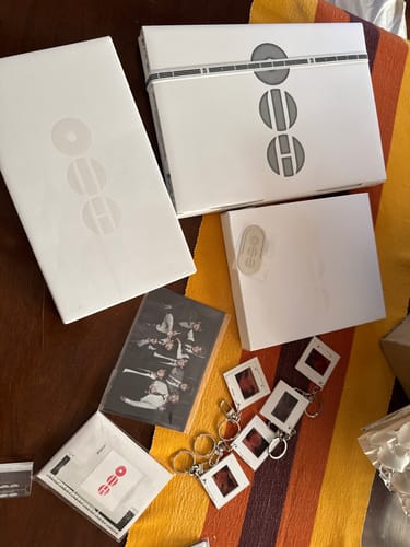 Customer's BTS ARIRANG album set laid out, showing the white album boxes, photocards, and slide-style keyrings.