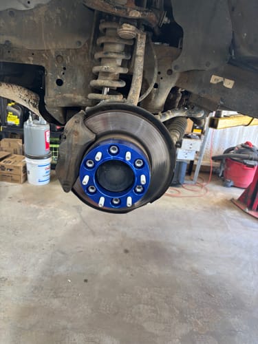 Customer's blue hubcentric wheel spacer installed on the wheel hub of their truck.
