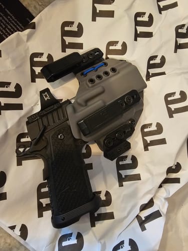 Customer's grey XIPHOS ELITE holster holding a black Staccato P handgun on top of branded paper.