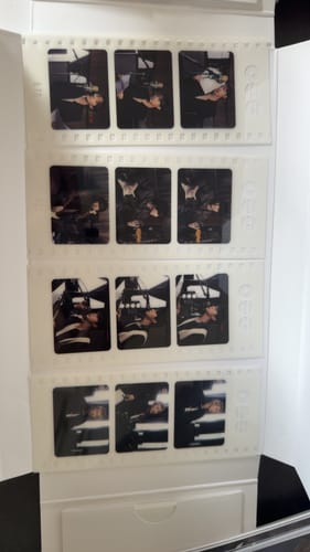 Customer's photo of filmstrip-style photocards from the BTS album set, arranged in white packaging.