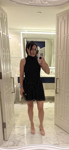 Reviewer taking a mirror selfie wearing the black Colette Polka Dot High Neck Mini Dress.