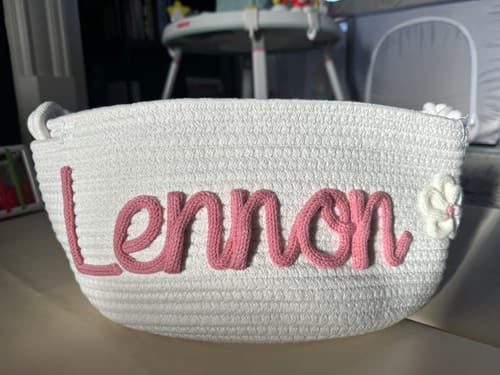 Customer's personalized white woven basket with the name 'Lennon' in pink lettering.