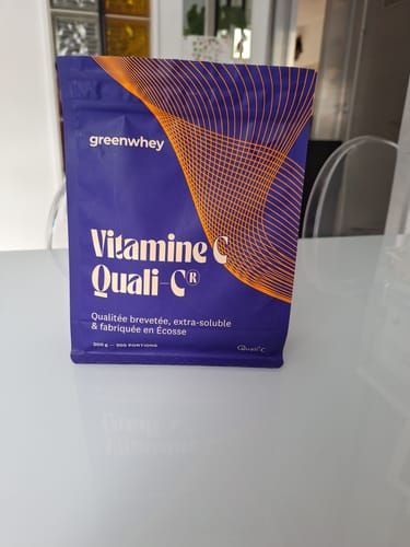 Un client montre le sachet violet de Vitamine C Quali-C de Greenwhey, posé sur une table.