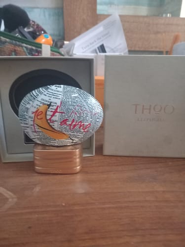 Recensore mostra il profumo L'Explicite con il suo flacone artistico su un tavolo, accanto alla scatola.
