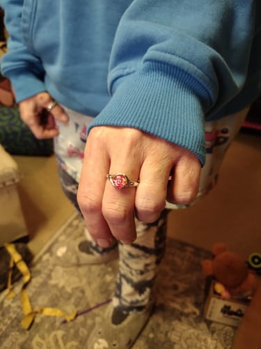 A customer's hand displaying the Forked Branch Ring with a vibrant pink stone on their finger.