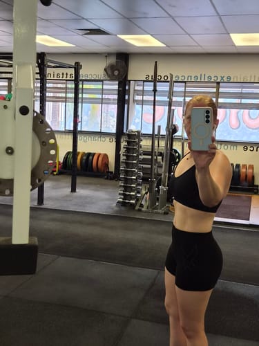 Reviewer at the gym showing their defined midsection after using Gut Fibre™ to reduce bloating.