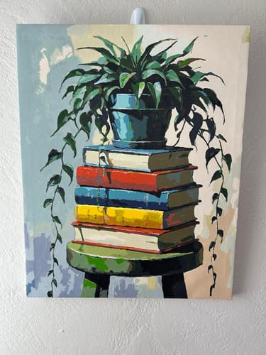Reviewer's completed painting from the Books and Plant Still Life kit hanging on a wall.