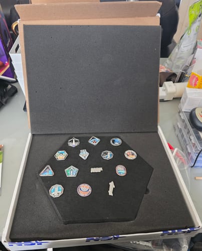 Customer's SpaceX Starship Flight Pin Collection in its open box, with the pins arranged on the black hexagonal display tile.