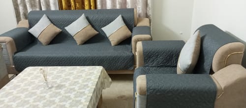 Customer's living room with a grey ultrasonic sofa cover fitted on a three-seater and a single-seater sofa.