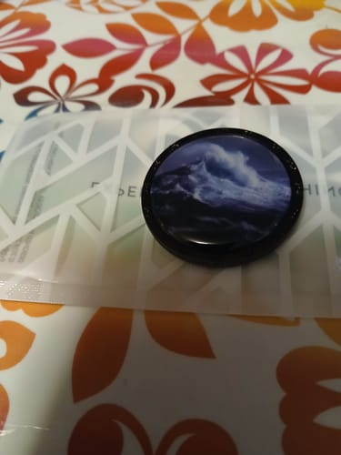 Customer's This Too Shall Pass Coin, featuring a powerful stormy sea design, resting on its packaging.