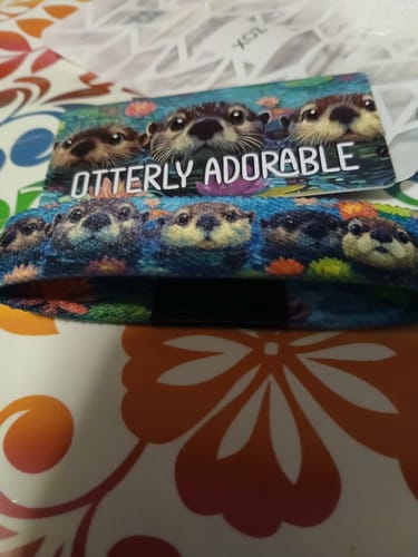 Close-up of a customer's 'Otterly Adorable' bracelet from the Otter Pack, shown with its matching collector's card.