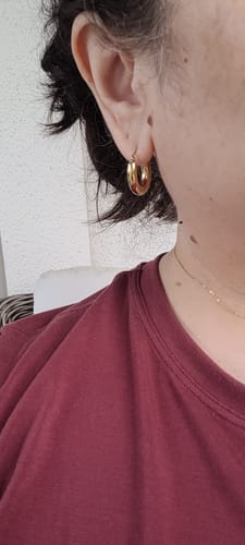Close-up of a reviewer wearing a gold Chubby Hoop Earring, showing its size and fit.