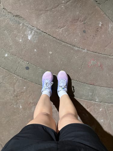 Reviewer standing in light purple Nike Women's Vomero 18 Running Shoes on a paved surface.