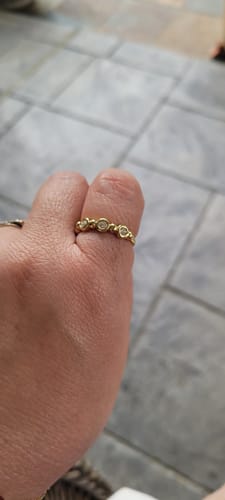 Customer's hand wearing the shiny Beaded Tennis Ring on their thumb.