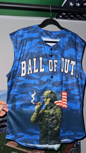 Reviewer's custom blue camo sleeveless baseball jersey with 'BALL OF DUTY' text and a soldier graphic, shown hanging.
