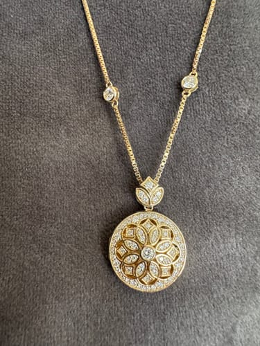 Reviewer's gorgeous Doveggs floral vintage locket. The intricate gold pendant has moissanite accents on it and the chain.