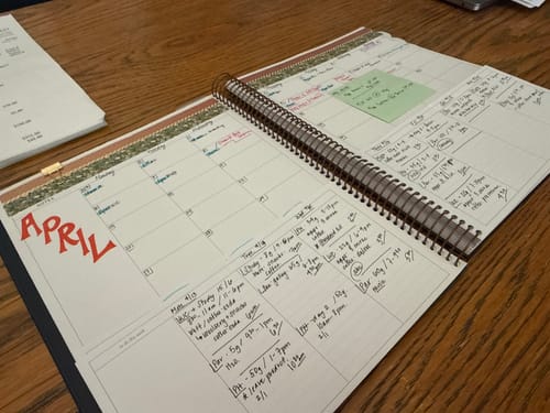 Reviewer's open Scout Planner showing the monthly calendar for April above the filled-in weekly planning sections.