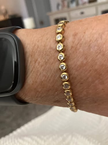 Reviewer's close-up of the gold Classic Bezel Tennis Bracelet on their wrist.