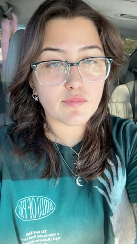 Reviewer wearing the Astrology Star Hoop Earring in their ear with other celestial jewelry.