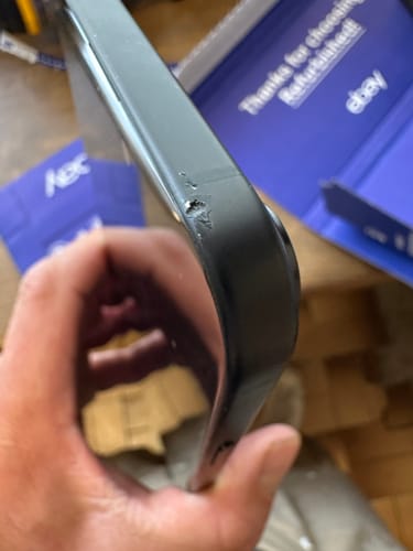 Close-up of a customer's refurbished iPhone 15 Plus, showing a small mark on the side frame.