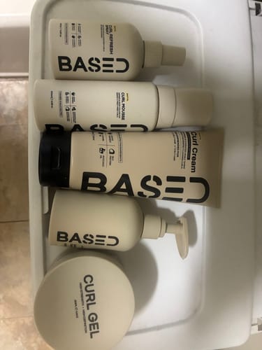 Customer's Complete Curly Kit, with the beige bottles and jars of hair products arranged in a tray.