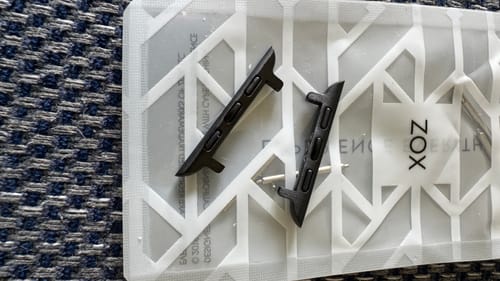 Customer's two black Watchband+ Adapters and a pin displayed on the product packaging.