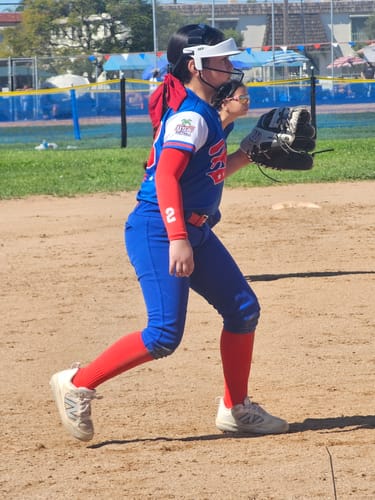Customer on a softball field in a fielding stance, wearing the NEO Softball Fielder's Mask.