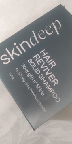 Packaging for the customer's HAIR REVIVER Solid Shampoo, shown in its dark rectangular box.