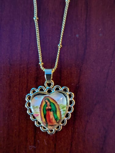 Reviewer's close-up of the Lupita Corazon Necklace, showing the gold scalloped heart pendant.