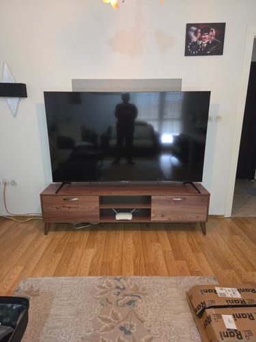 Değerlendirenin oturma odasında kurulu, üzerinde televizyon olan ceviz rengi Rani A9 Tv Ünitesi.
