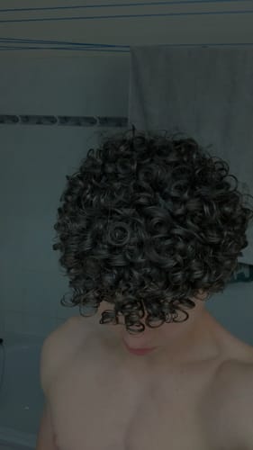 Reviewer showing their defined, curly hair after using the Based Bodyworks Leave-in Conditioner.