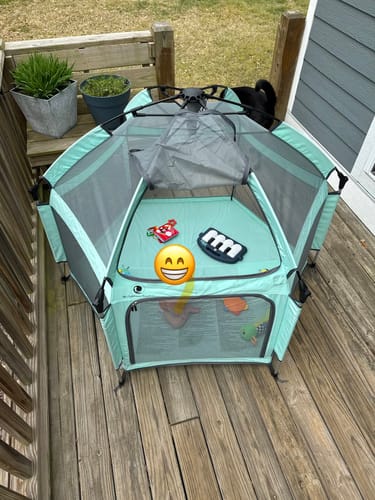 Customer's mint Pop 'N Go Playpen set up on a wooden deck with the UV shade partially attached and toys inside.