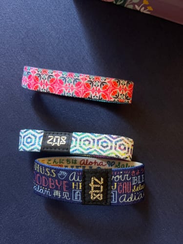 Reviewer's three colorful ZOX straps from a Subscription Mystery 3-Pack displayed on a blue surface.