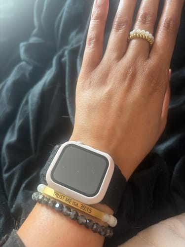 Customer's wrist wearing a gold bar bracelet custom engraved with 'Trust Me Isa. 30:15', stacked with other jewelry.