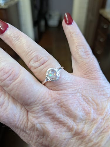 Close-up of a customer's hand wearing the beautiful sterling silver Braided Oval Ring.