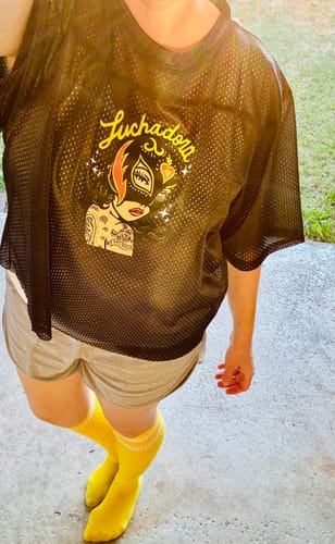 Customer showing the fit of the black mesh Team Lucha Jersey with its colorful Luchadora graphic.